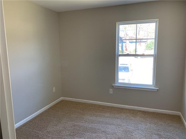 carpeted spare room featuring baseboards