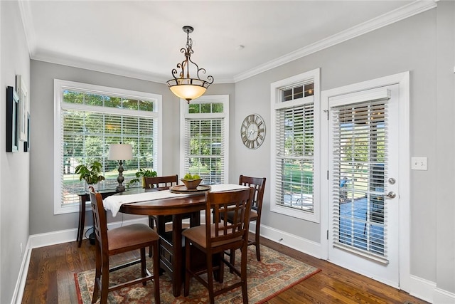 dining area featuring ornamental molding, baseboards, and wood finished floors