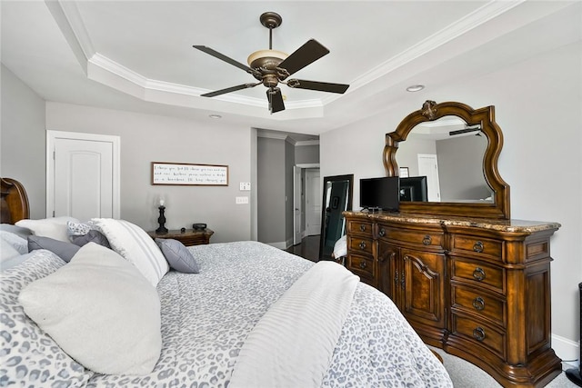 bedroom featuring ornamental molding, ceiling fan, a tray ceiling, and baseboards