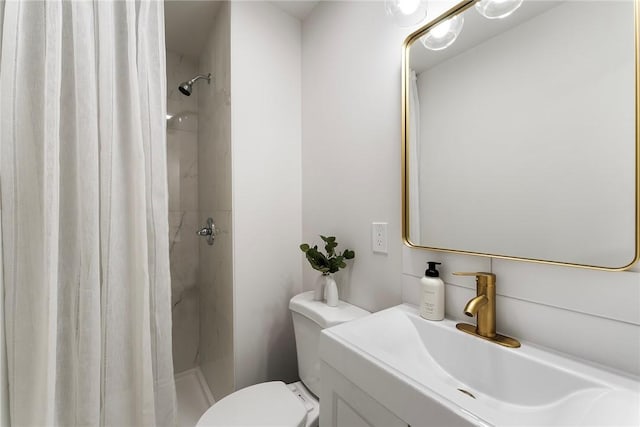 bathroom with toilet, a stall shower, and vanity