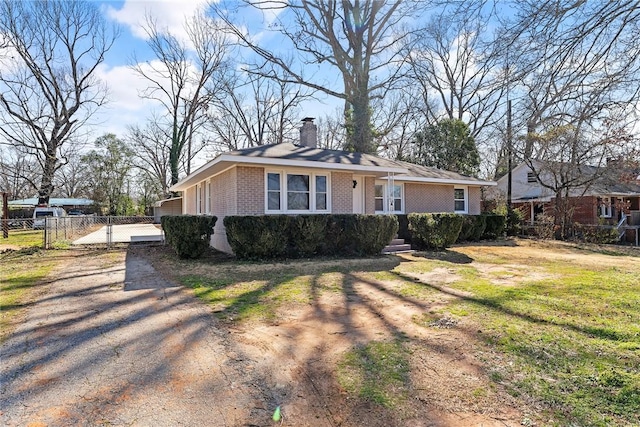 view of front facade with brick siding, fence, driveway, a gate, and a chimney