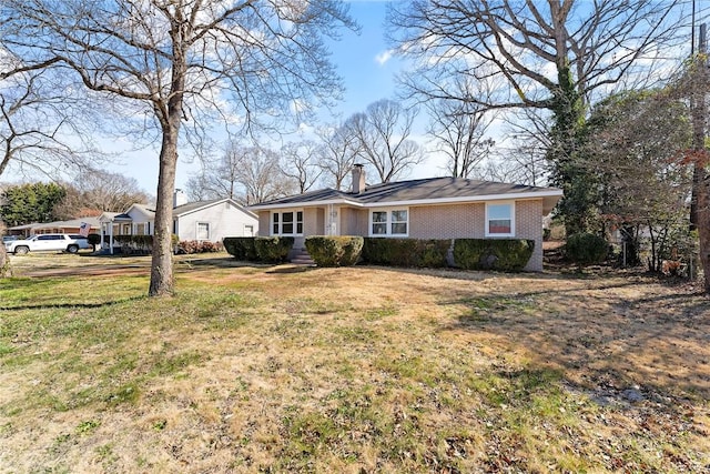 ranch-style house with a front yard, brick siding, and a chimney