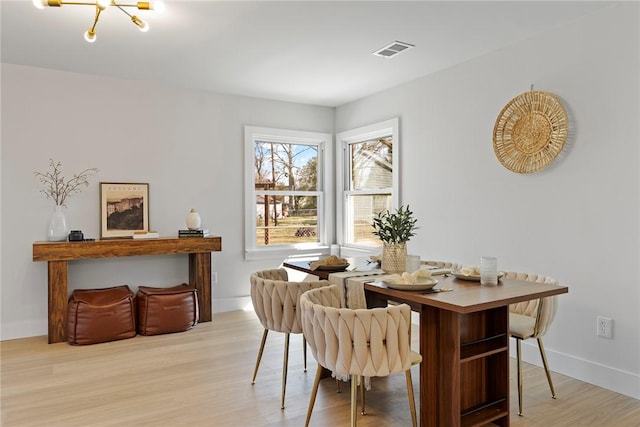 dining room with an inviting chandelier, wood finished floors, visible vents, and baseboards