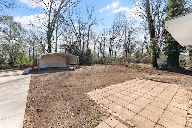 view of yard featuring concrete driveway and a carport