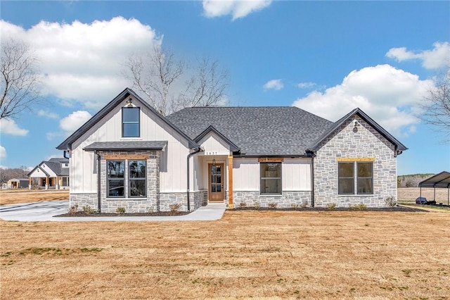 modern inspired farmhouse with stone siding, a shingled roof, board and batten siding, and a front yard