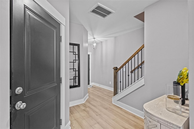 entryway featuring visible vents, baseboards, stairway, and light wood finished floors