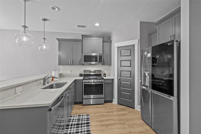 kitchen with visible vents, gray cabinets, appliances with stainless steel finishes, and a sink