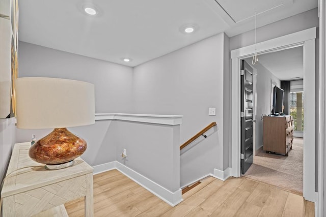 hallway featuring baseboards, attic access, an upstairs landing, recessed lighting, and wood finished floors