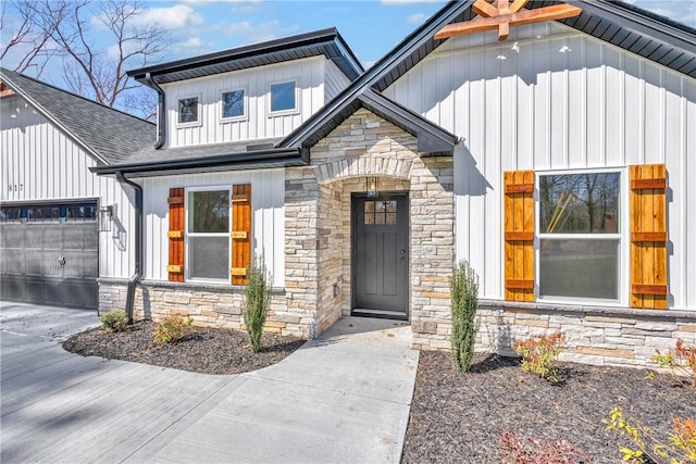 property entrance featuring board and batten siding, stone siding, a shingled roof, and a garage