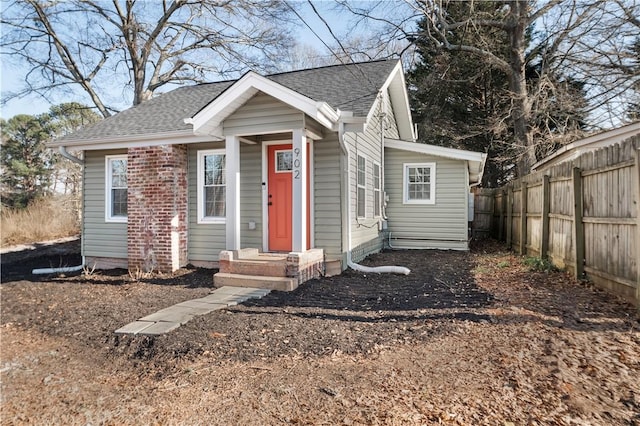 view of front of property featuring a shingled roof and fence