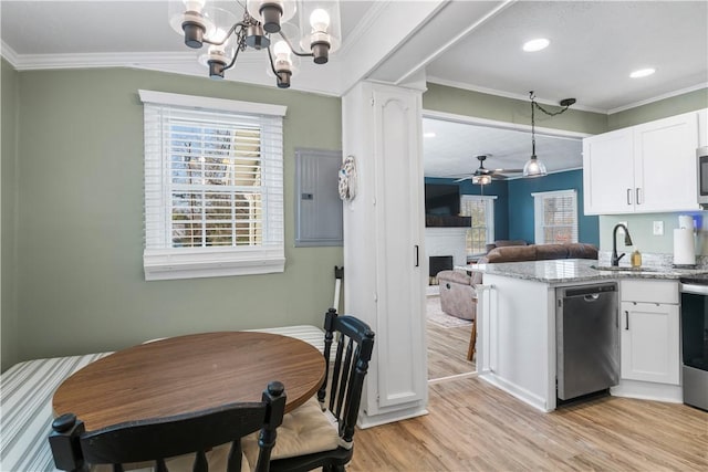 kitchen with light wood-style flooring, appliances with stainless steel finishes, crown molding, white cabinetry, and a sink