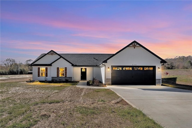 modern inspired farmhouse with concrete driveway, roof with shingles, and an attached garage