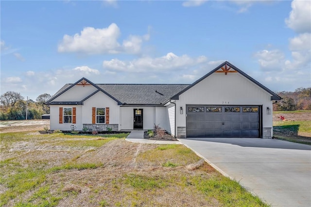 modern farmhouse style home featuring a garage, concrete driveway, a shingled roof, and stone siding