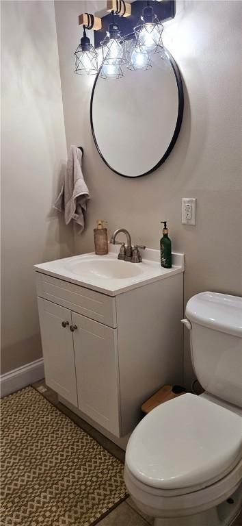 bathroom with baseboards, vanity, and toilet