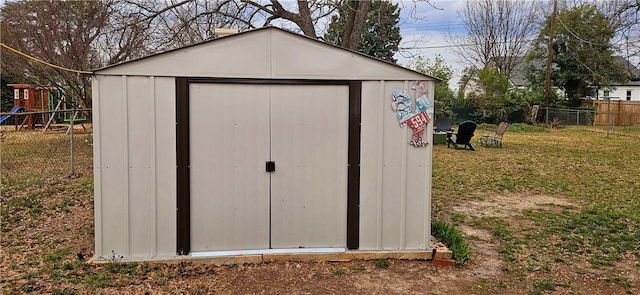 view of shed with a playground and fence