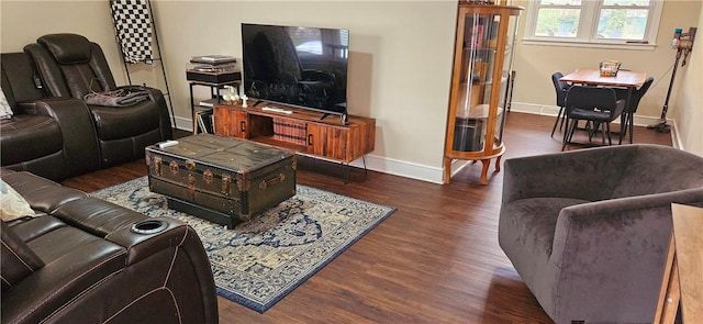 living area with baseboards and wood finished floors