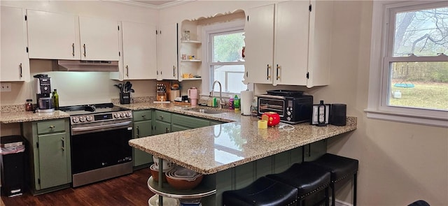 kitchen featuring under cabinet range hood, a peninsula, a sink, stainless steel electric range oven, and open shelves