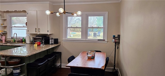 kitchen with crown molding, white cabinets, a sink, and open shelves