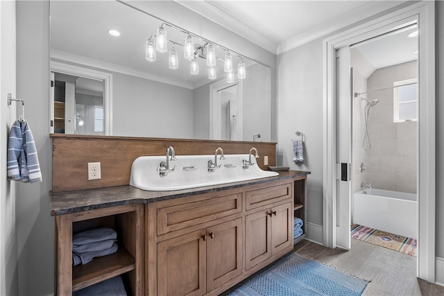 bathroom featuring ornamental molding, wood finished floors, vanity, and shower / bathing tub combination