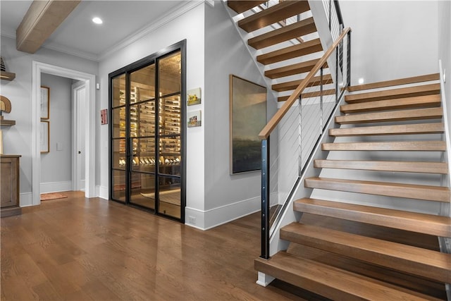 wine cellar featuring baseboards, ornamental molding, beamed ceiling, wood finished floors, and recessed lighting