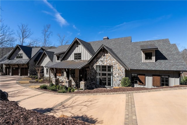 view of front of home featuring a standing seam roof, metal roof, board and batten siding, and concrete driveway