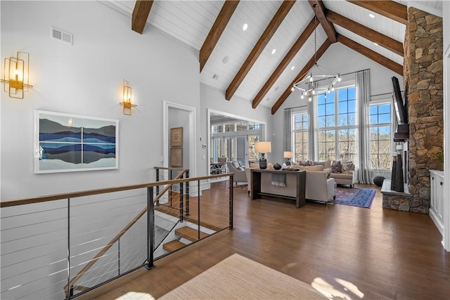 interior space with high vaulted ceiling, visible vents, beamed ceiling, and wood finished floors