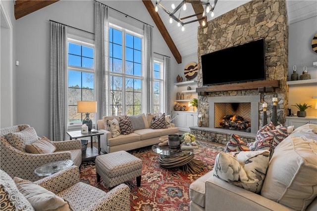 living room featuring high vaulted ceiling, beamed ceiling, a fireplace, and an inviting chandelier