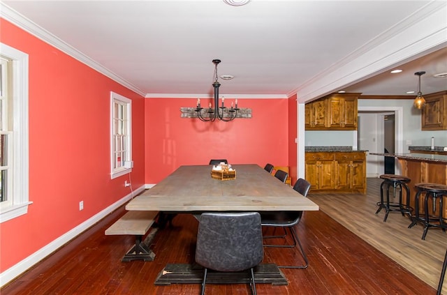 dining room featuring dark wood-style floors, a notable chandelier, crown molding, and baseboards