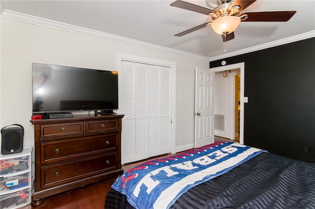 bedroom featuring a closet, visible vents, dark wood-type flooring, and ornamental molding