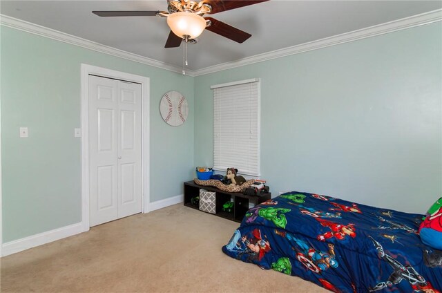 bedroom featuring carpet, a closet, crown molding, and baseboards