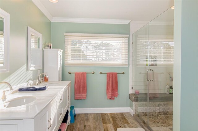 bathroom with crown molding, a sink, a shower stall, and wood finished floors