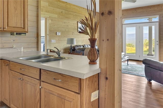 kitchen with wood walls, open floor plan, and a sink