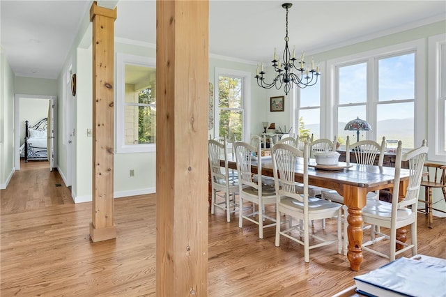 dining room featuring light wood finished floors, a chandelier, and crown molding