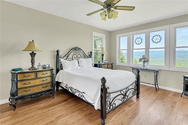 bedroom featuring baseboards, a ceiling fan, and light wood-style floors