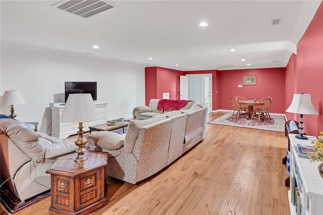 living room with baseboards, light wood-style flooring, visible vents, and recessed lighting