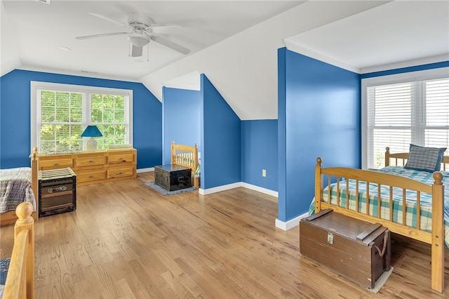 bedroom with lofted ceiling, baseboards, and wood finished floors