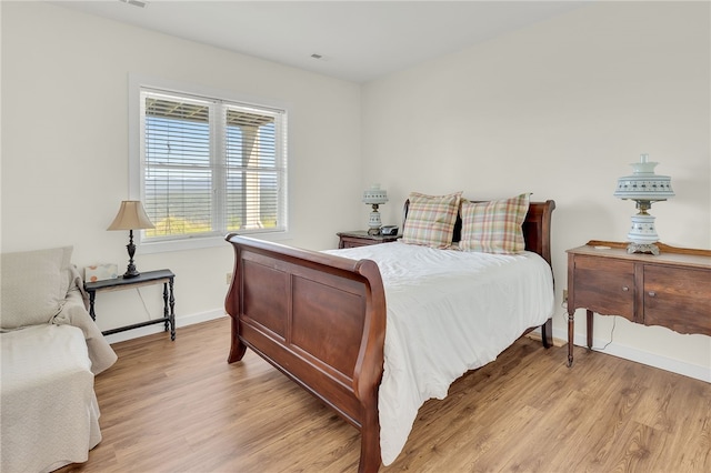 bedroom with light wood-style flooring and baseboards