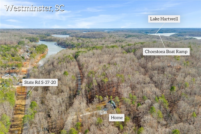 aerial view featuring a water view and a wooded view