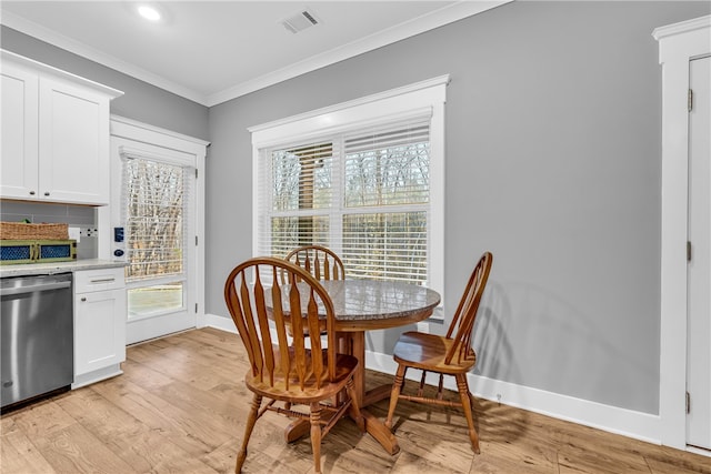 dining space with ornamental molding, visible vents, light wood-style flooring, and baseboards