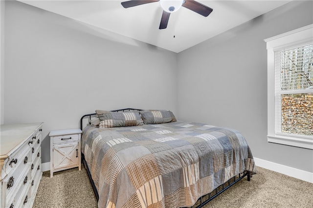 bedroom featuring multiple windows, light carpet, and baseboards