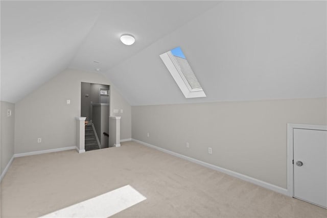 bonus room featuring carpet floors, lofted ceiling with skylight, and baseboards