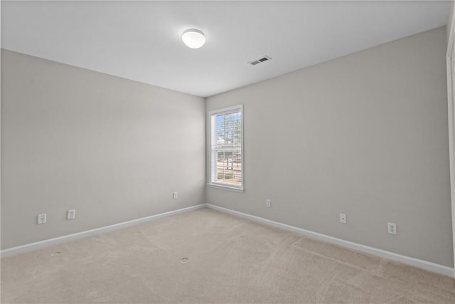 unfurnished room with baseboards, visible vents, and light colored carpet