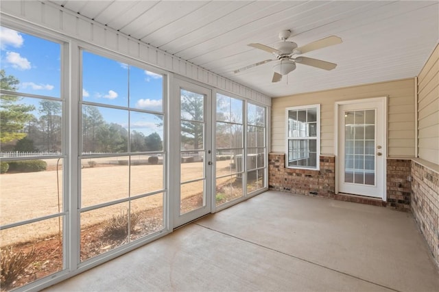 unfurnished sunroom with ceiling fan