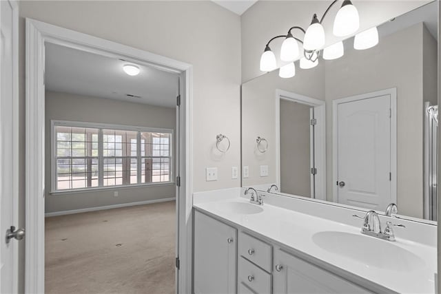 full bathroom with double vanity, baseboards, and a sink