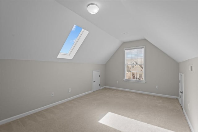 additional living space featuring carpet, visible vents, vaulted ceiling, and baseboards
