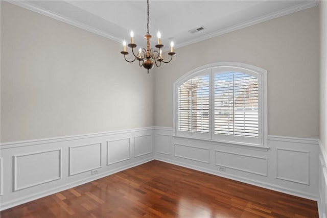 spare room with ornamental molding, dark wood-type flooring, wainscoting, and visible vents