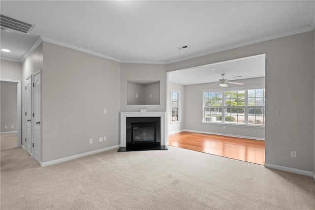 unfurnished living room with carpet floors, a fireplace with flush hearth, visible vents, and baseboards