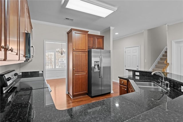 kitchen featuring crown molding, appliances with stainless steel finishes, brown cabinetry, dark wood-type flooring, and a sink