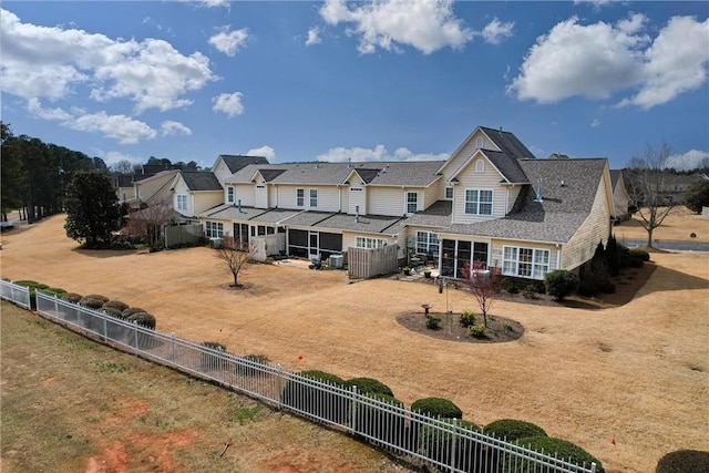 rear view of house with a fenced backyard and a residential view