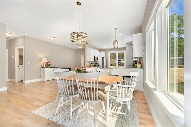 dining space with light wood-type flooring, baseboards, and recessed lighting